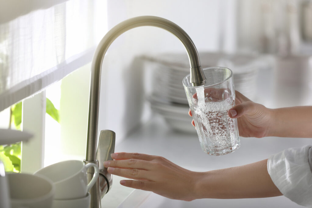 lady pouring water form her faucet into a water glass in Los Angeles