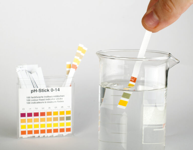 someone using a litmus strip to test for water ph